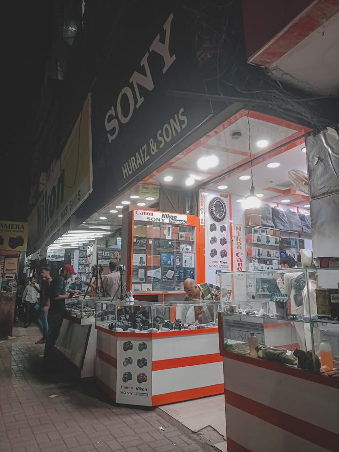 A bustling electronics store open at night showcasing cameras and accessories.